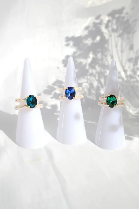 Three shades of blue cubic zirconia and freshwater pearls in elegant rings, inspired by the ocean’s timeless beauty.