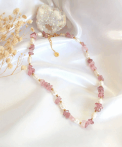 Close-up of a handcrafted choker necklace featuring natural Strawberry Quartz crystals and white freshwater pearls, with an 18K gold-plated adjustable clasp.