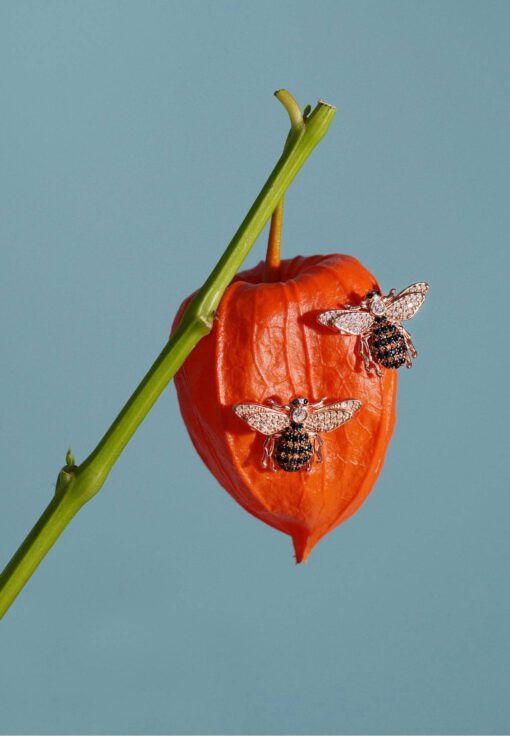 Close-up of 18K gold plated Honey Bee stud earrings with detailed wings and a polished finish, displayed on a soft neutral background.