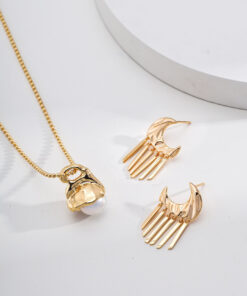 Gold moon tassel earrings with celestial design, displayed on minimal background.