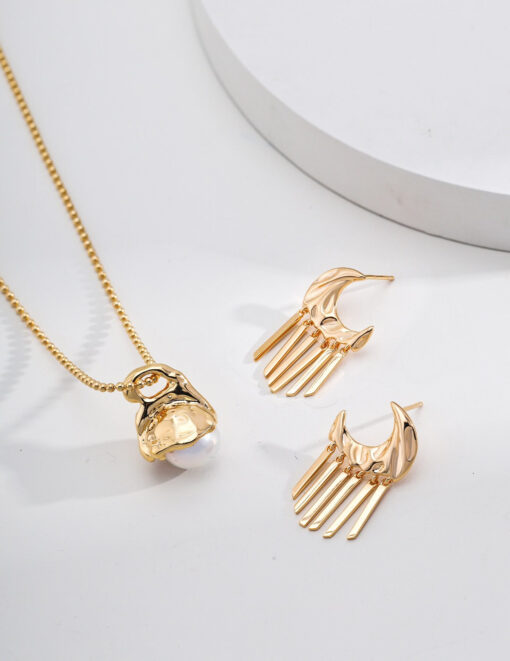 Gold moon tassel earrings with celestial design, displayed on minimal background.