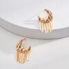 Gold moon tassel earrings with celestial design, displayed on minimal background.