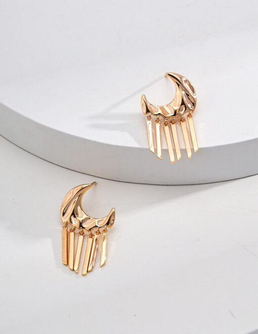 Gold moon tassel earrings with celestial design, displayed on minimal background.