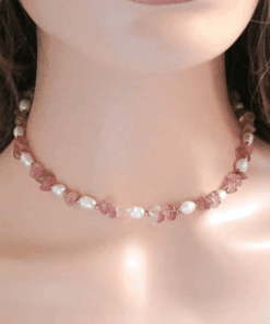Close-up of a handcrafted choker necklace featuring natural Strawberry Quartz crystals and white freshwater pearls, with an 18K gold-plated adjustable clasp.