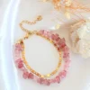 Double-layered Strawberry Quartz bracelet with 24K gold accents styled on a neutral background.